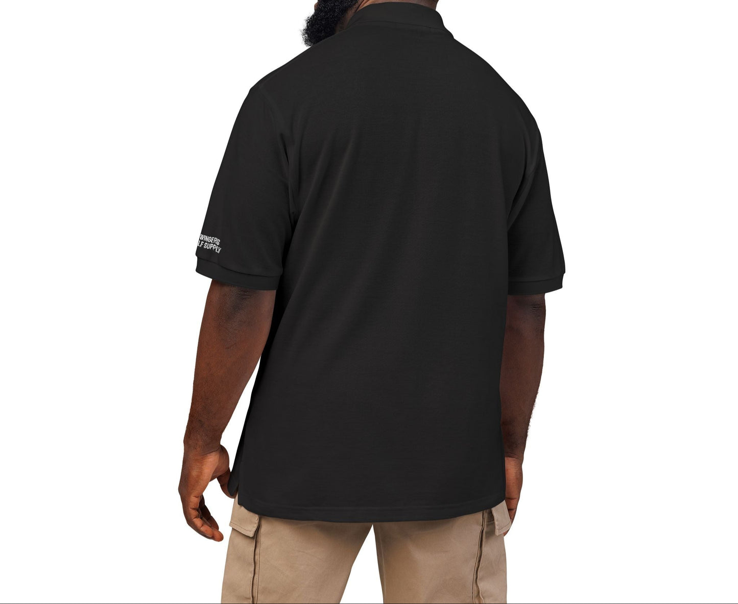 Man wearing a black shirt with a logo on the back, standing against a white background