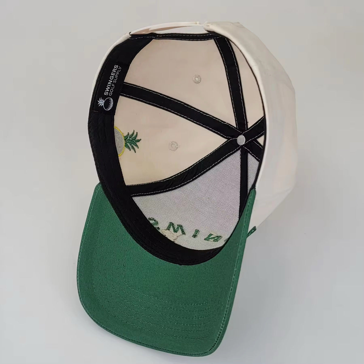 Cream and green 5-panel golf snapback hat with SWINGERS Golf Supply logo