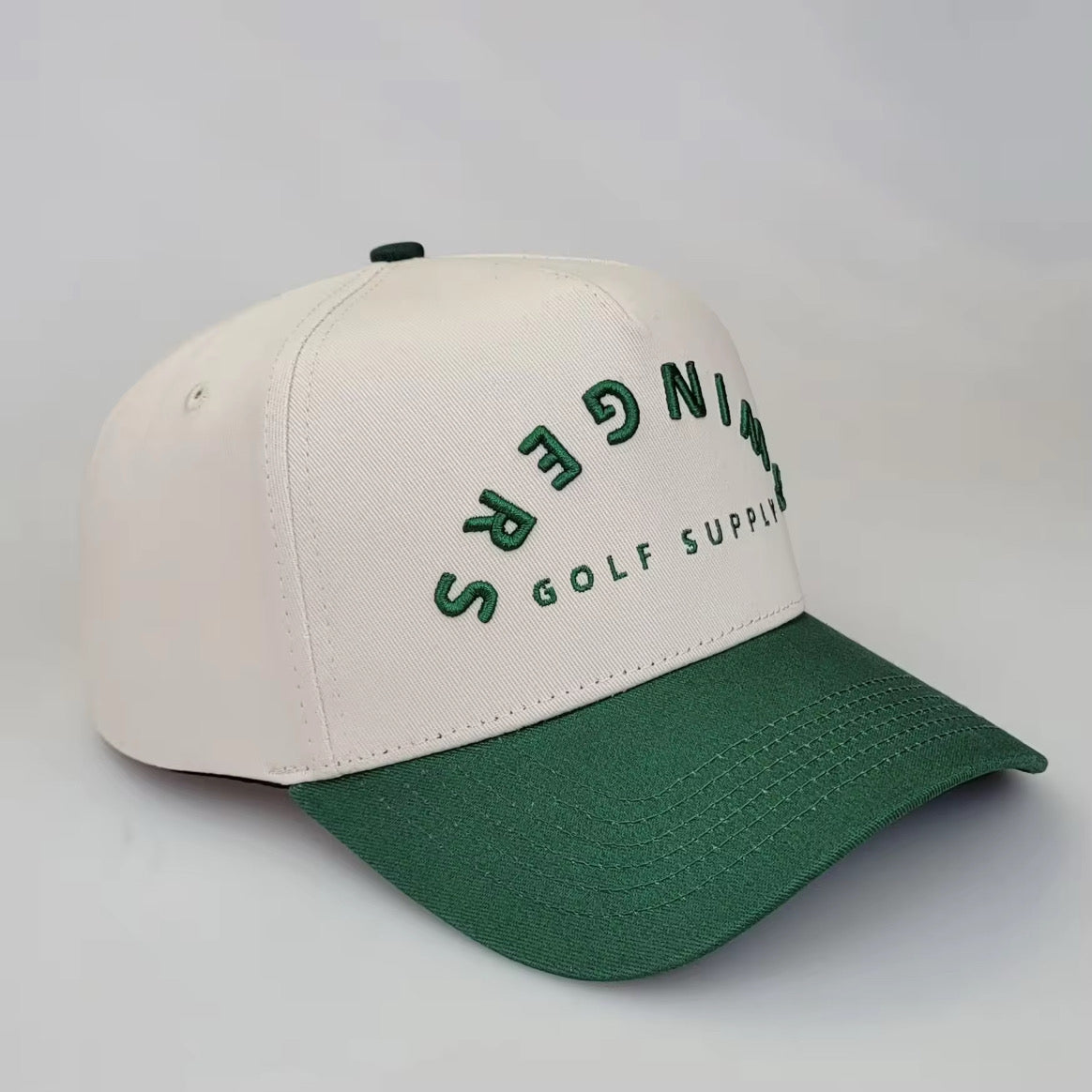 Cream and green 5-panel golf snapback hat with SWINGERS Golf Supply logo