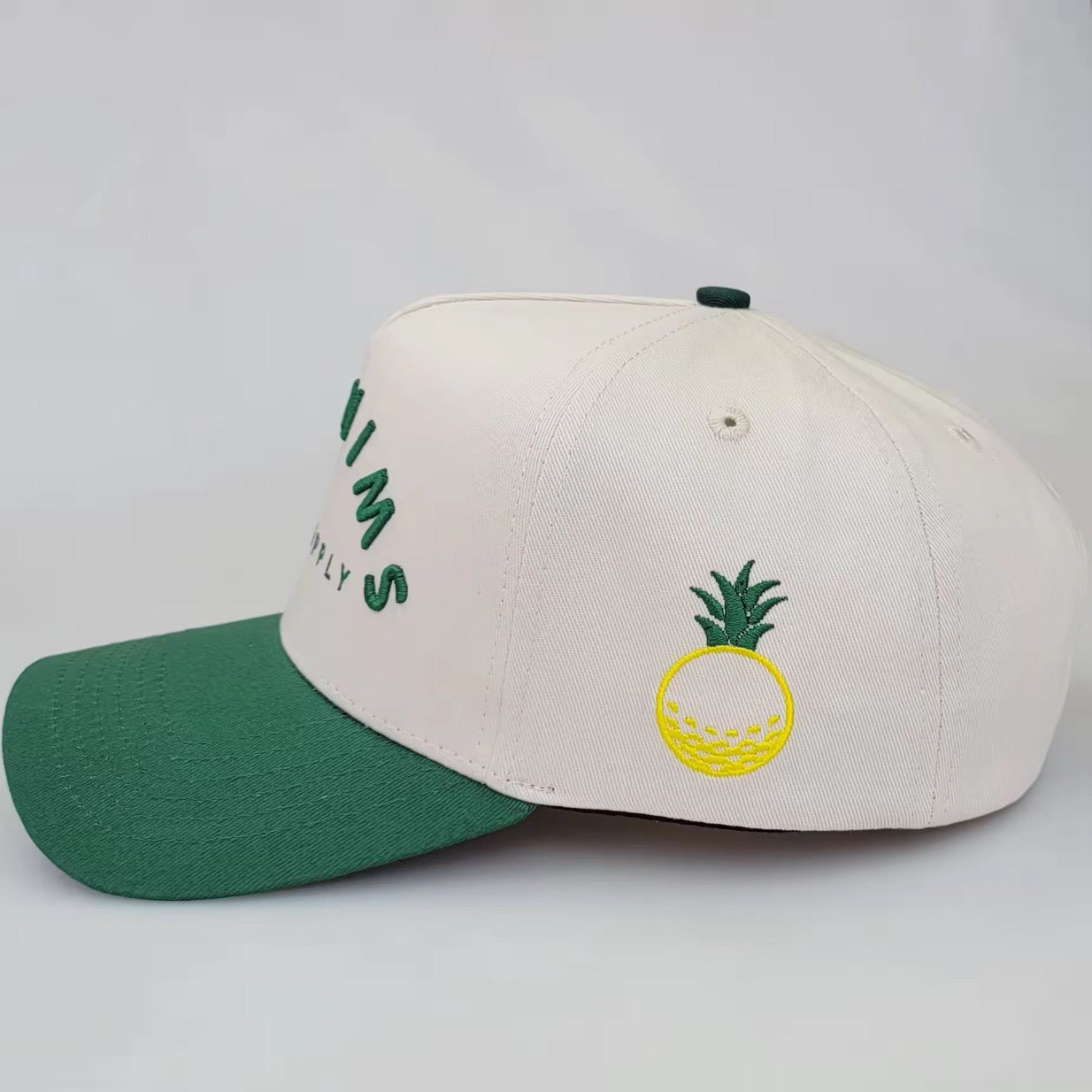 Cream and green 5-panel golf snapback hat with SWINGERS Golf Supply logo