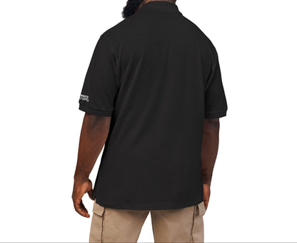 Man wearing a black shirt with a logo on the back, standing against a white background