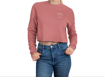 Person wearing a pink cropped sweatshirt and blue jeans on a white background