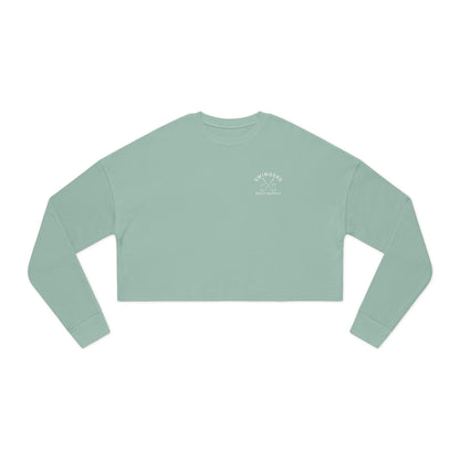Light green long-sleeve crop top with a logo on a white background